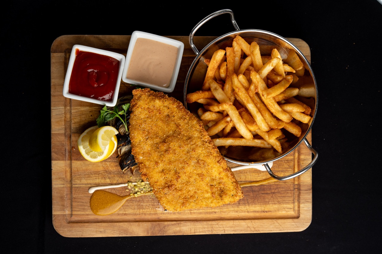 Golden crispy kosher schnitzel served with fries at Shawarma Bar & Grill House